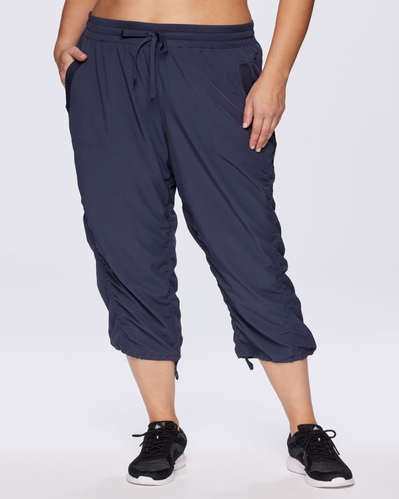 Front of a model wearing a size 2X Lumen Lightweight Capri Pant in Smoke Blue by RBX Active. | dia_product_style_image_id:348481